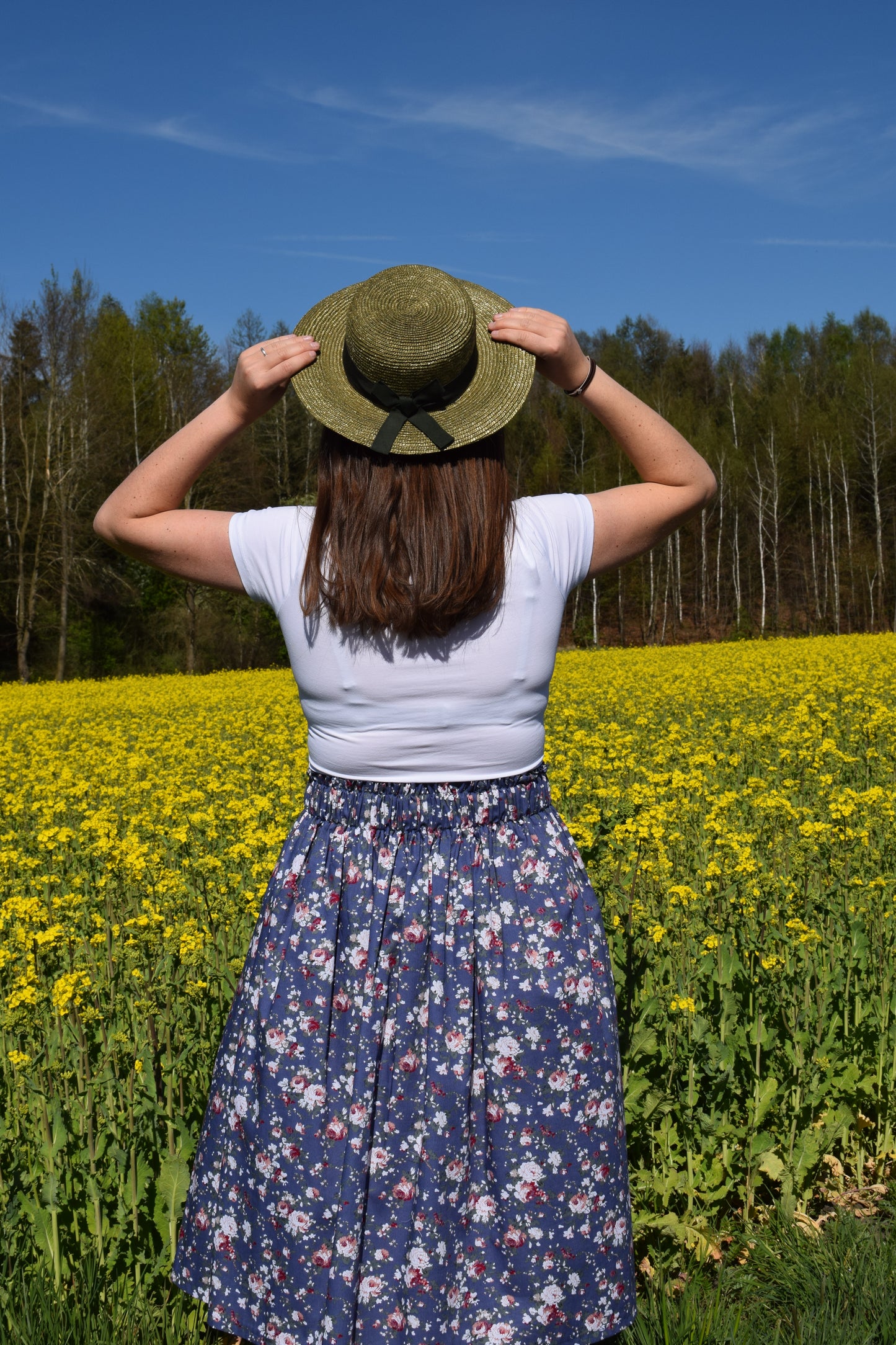 Frau mit Hut und Rock am Blumenfeld