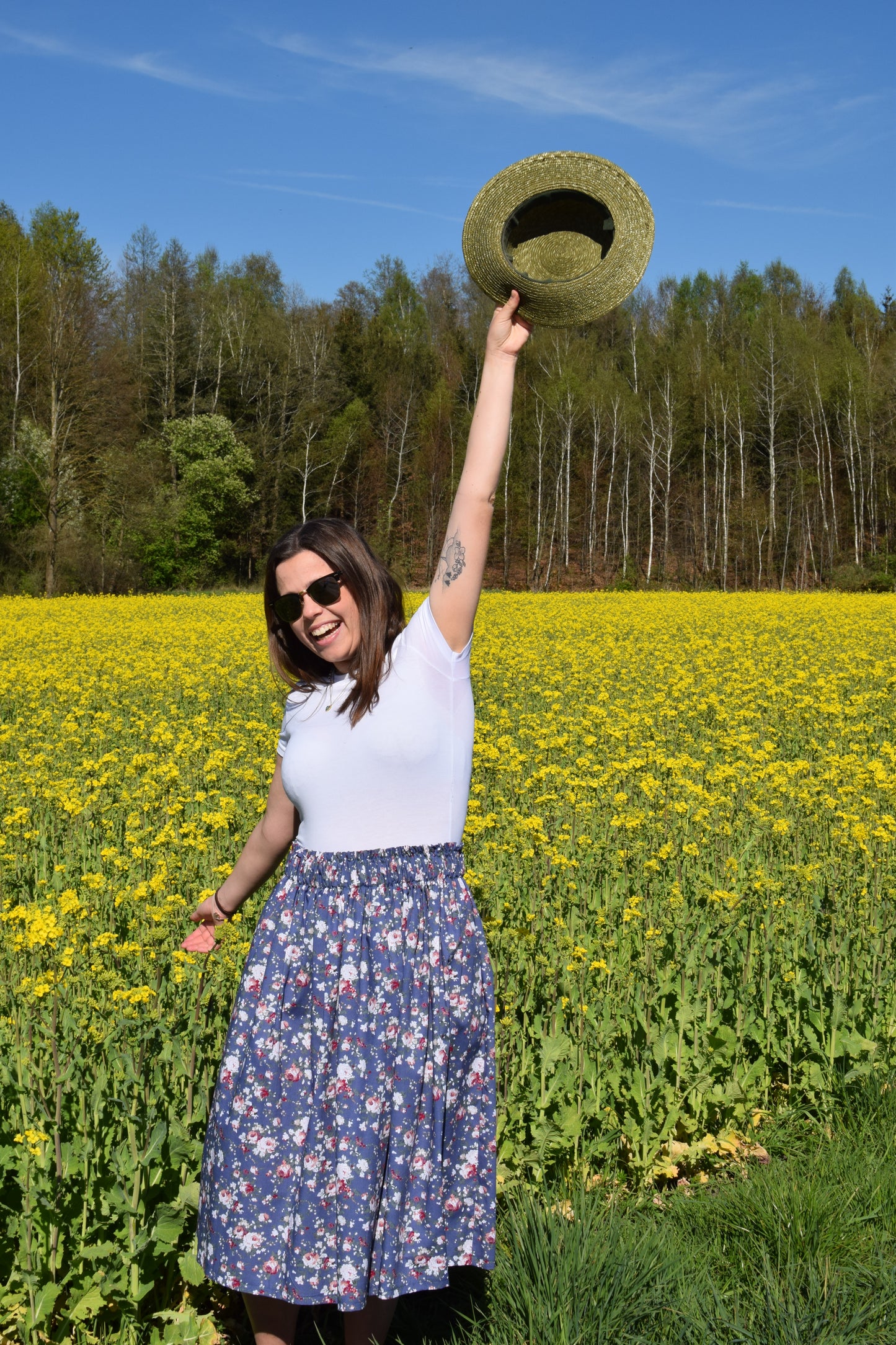 Frau mit Blumenrock blau und Hut am Blumenfeld