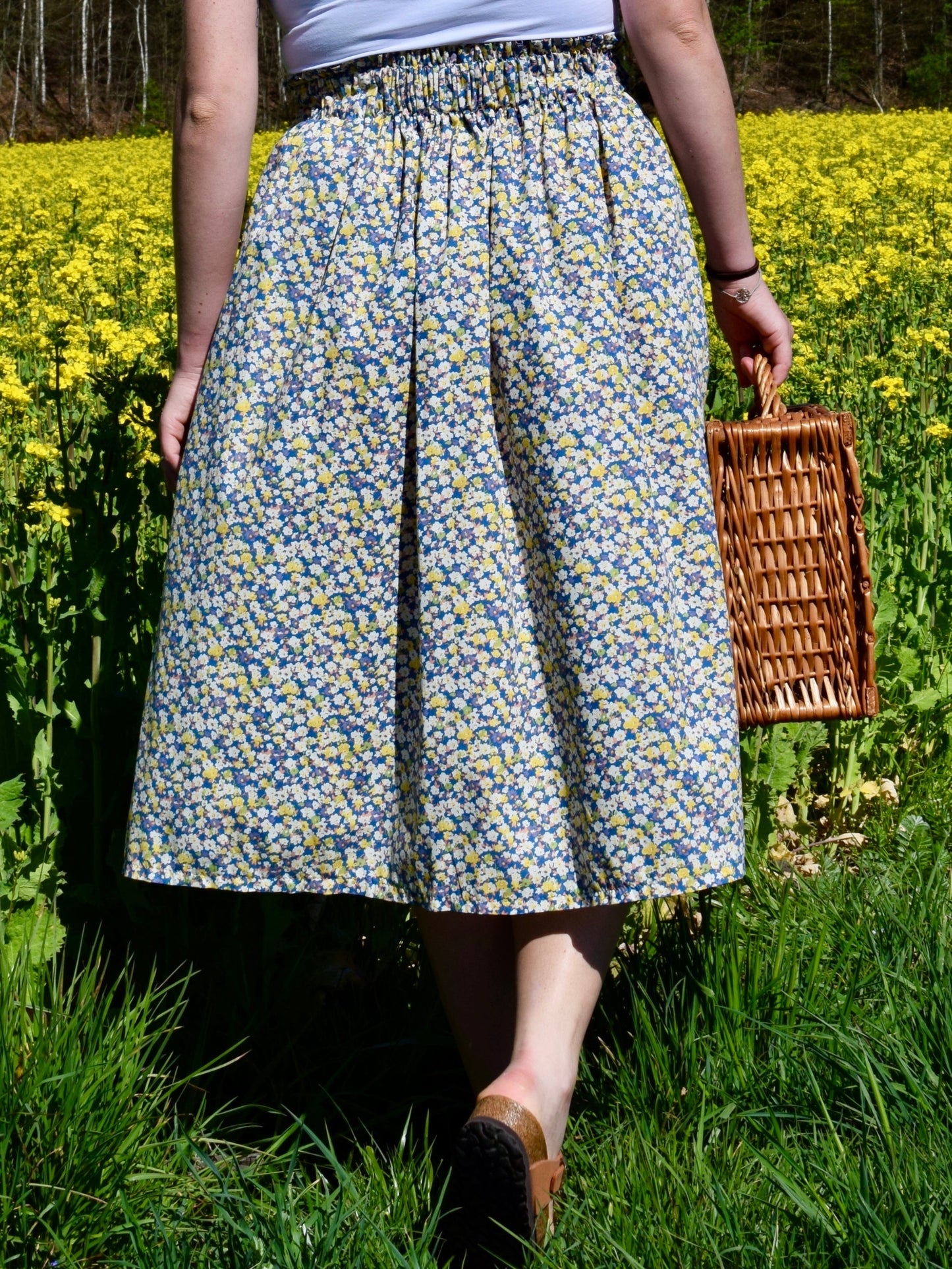 Frau in Blumenrock vor Feld