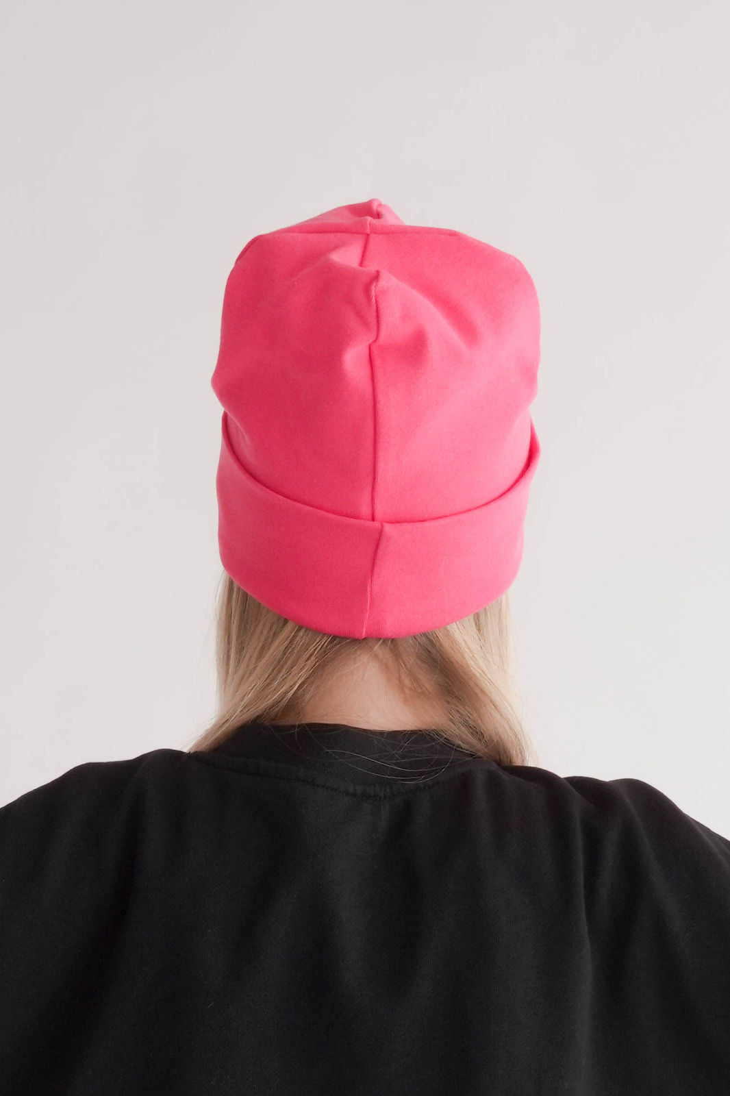 Frau mit pinker Mütze Hinteransicht