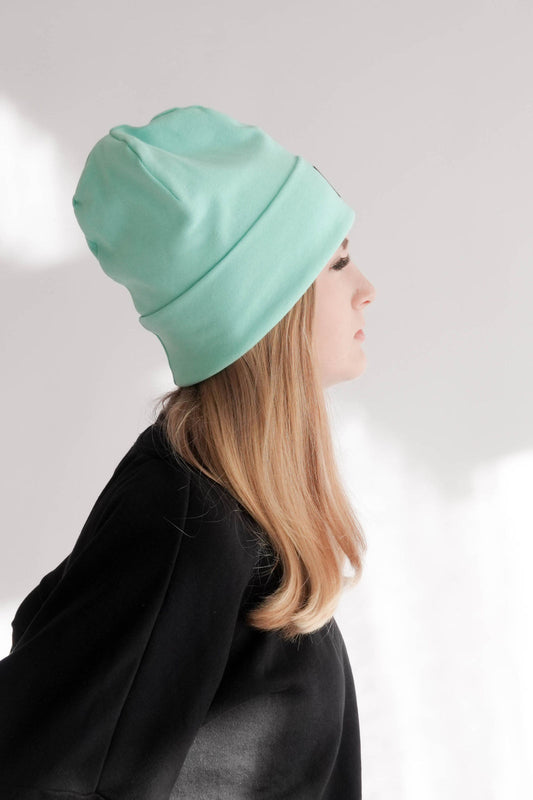 Frau mit mintfarbiger Mütze Seitenansicht