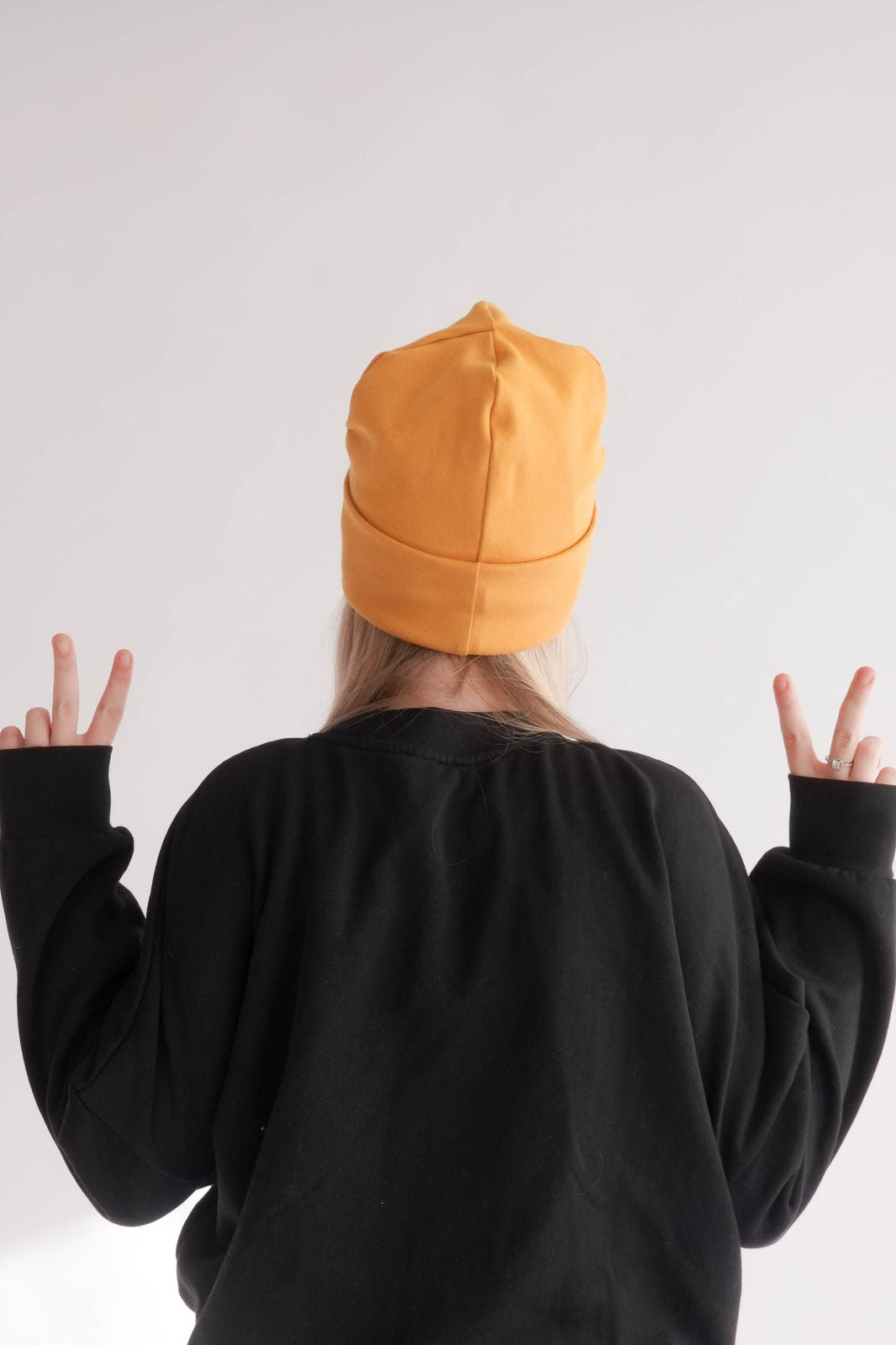 Frau mit gelber Mütze Hinteransicht